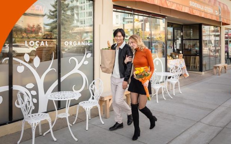 a man and woman posing for a picture outside a restaurant