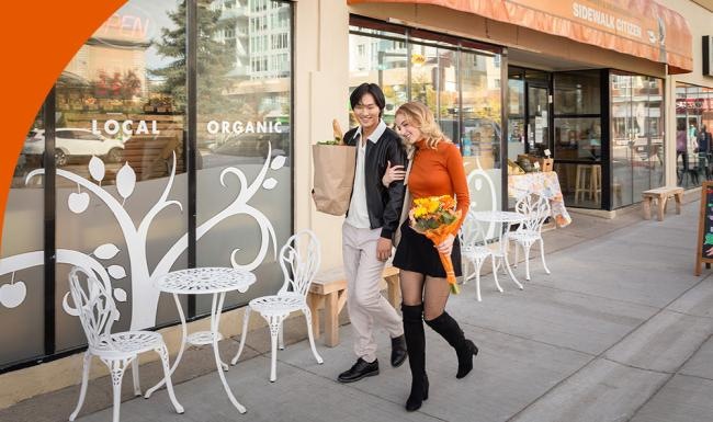 a man and woman posing for a picture outside a restaurant